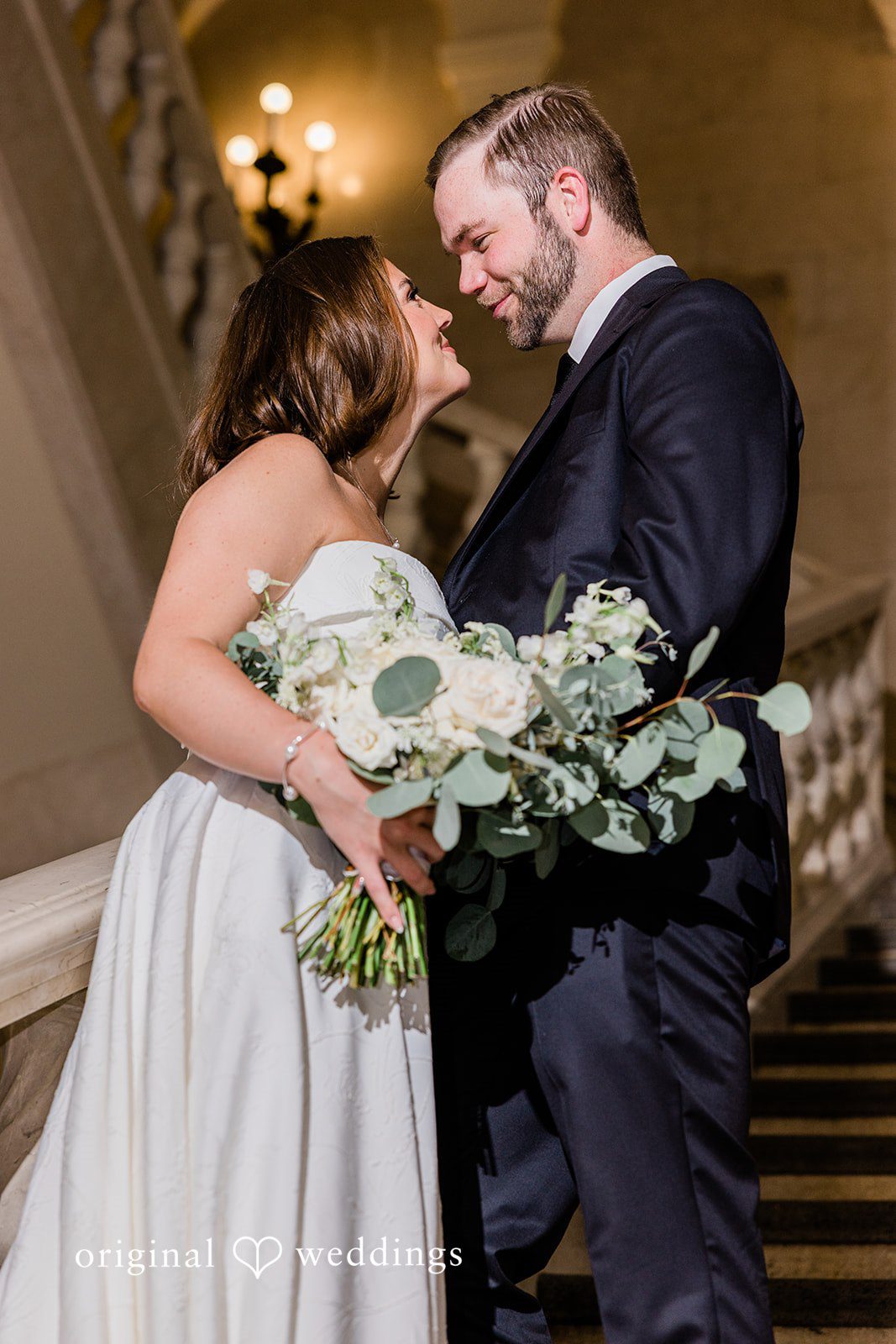 Luke + Madison Bride and groom sharing a romantic moment on the staircase at St. Clair Ballroom