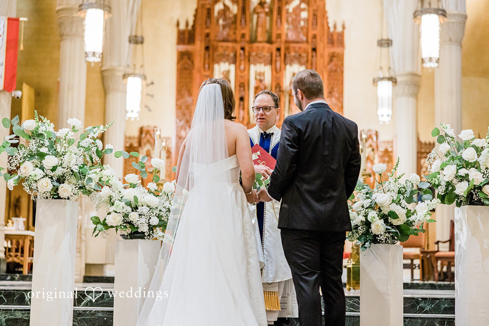 Luke + Madison Couple posing together while looking at the priest at St. Clair Ballroom captured by Cleveland Wedding Photographers from Original Weddings.