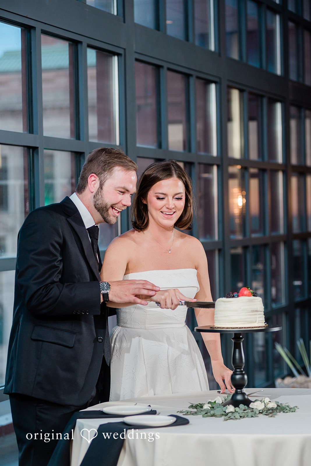Luke + Madison Bride and groom cutting their wedding cake at St. Clair Ballroom captured by Cleveland Wedding Photographers from Original Weddings.