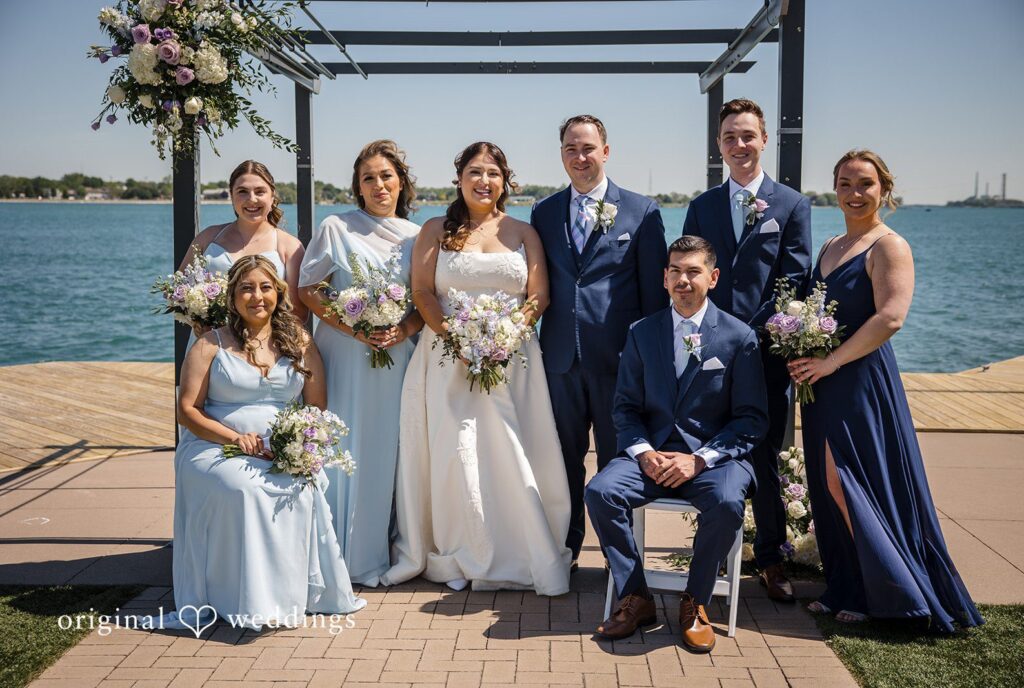 James + Nora Detroit Wedding Photographers capturing couple smiling with bridesmaids and groomsmen at St. Clair Inn by Original Weddings