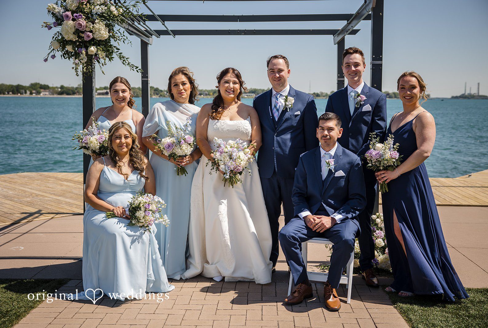 Detroit Wedding Photographers capturing couple smiling with bridesmaids and groomsmen at St. Clair Inn by Original Weddings