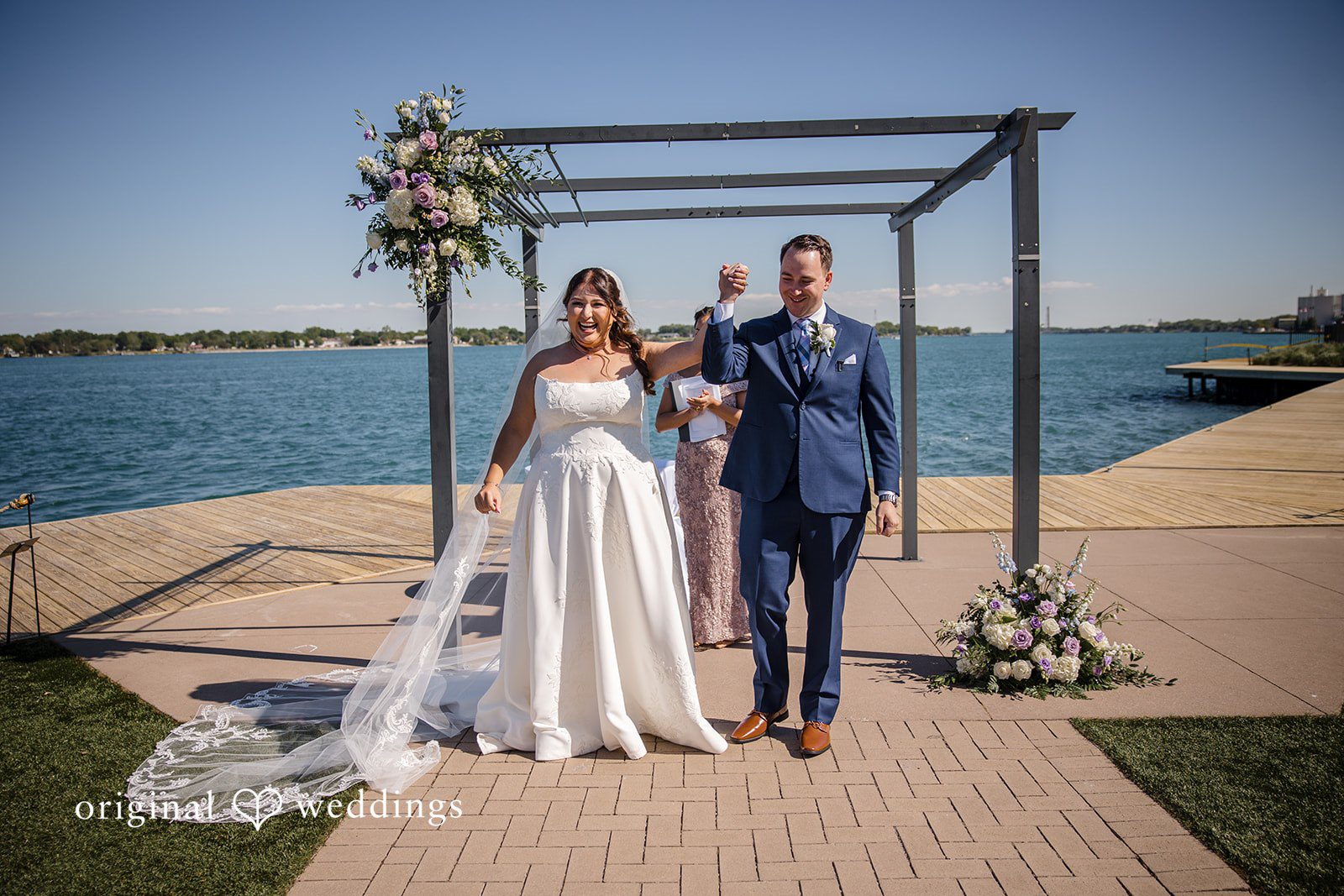 James + Nora Detroit Wedding Photographers capturing couple holding hands and smiling at St. Clair Inn by Original Weddings