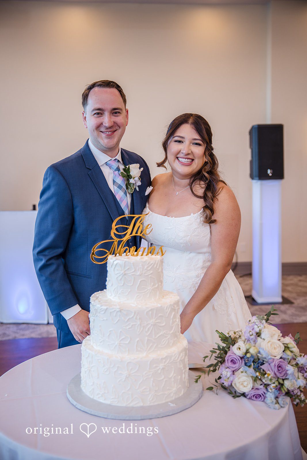 James + Nora Bride and groom posing in front of the wedding cake at St. Clair Inn
