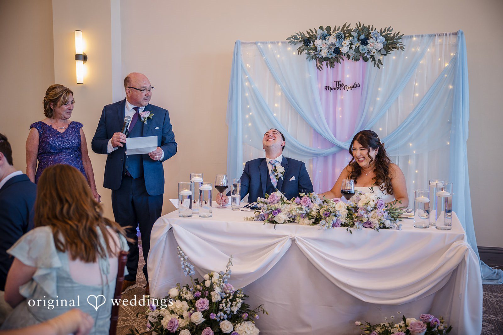 James + Nora Bride and groom smiling at the reception table at St. Clair Inn