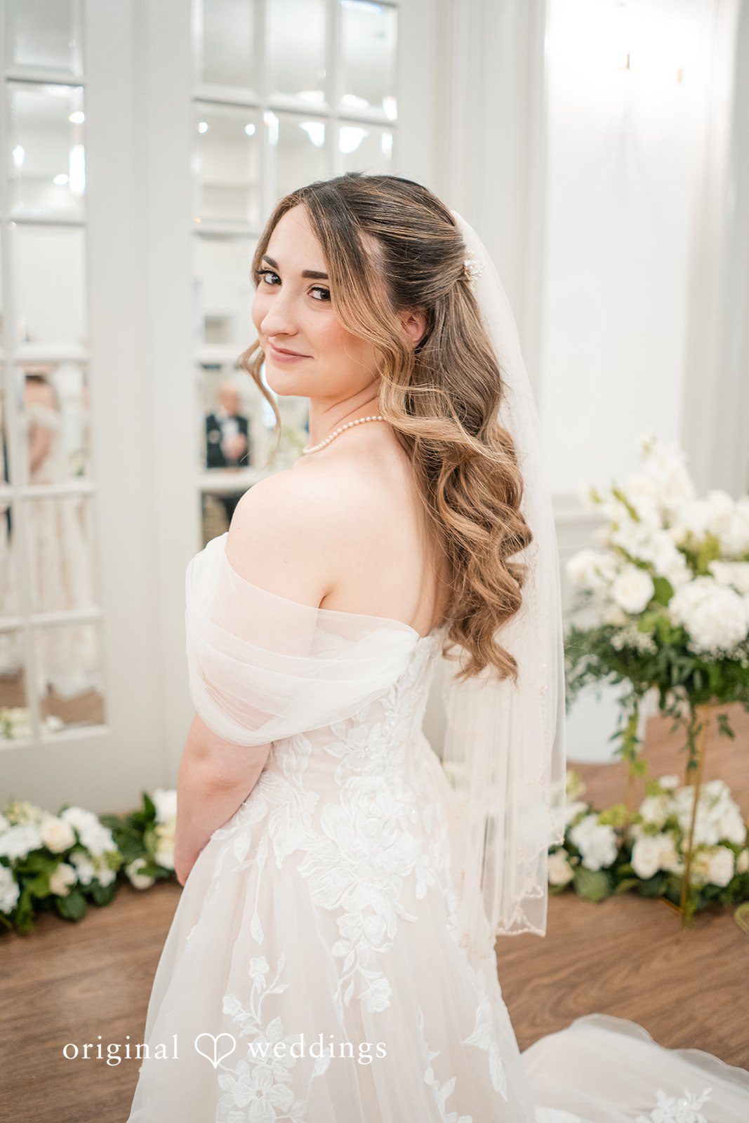Romantic bridal portrait featuring soft curls and a flowing wedding veil