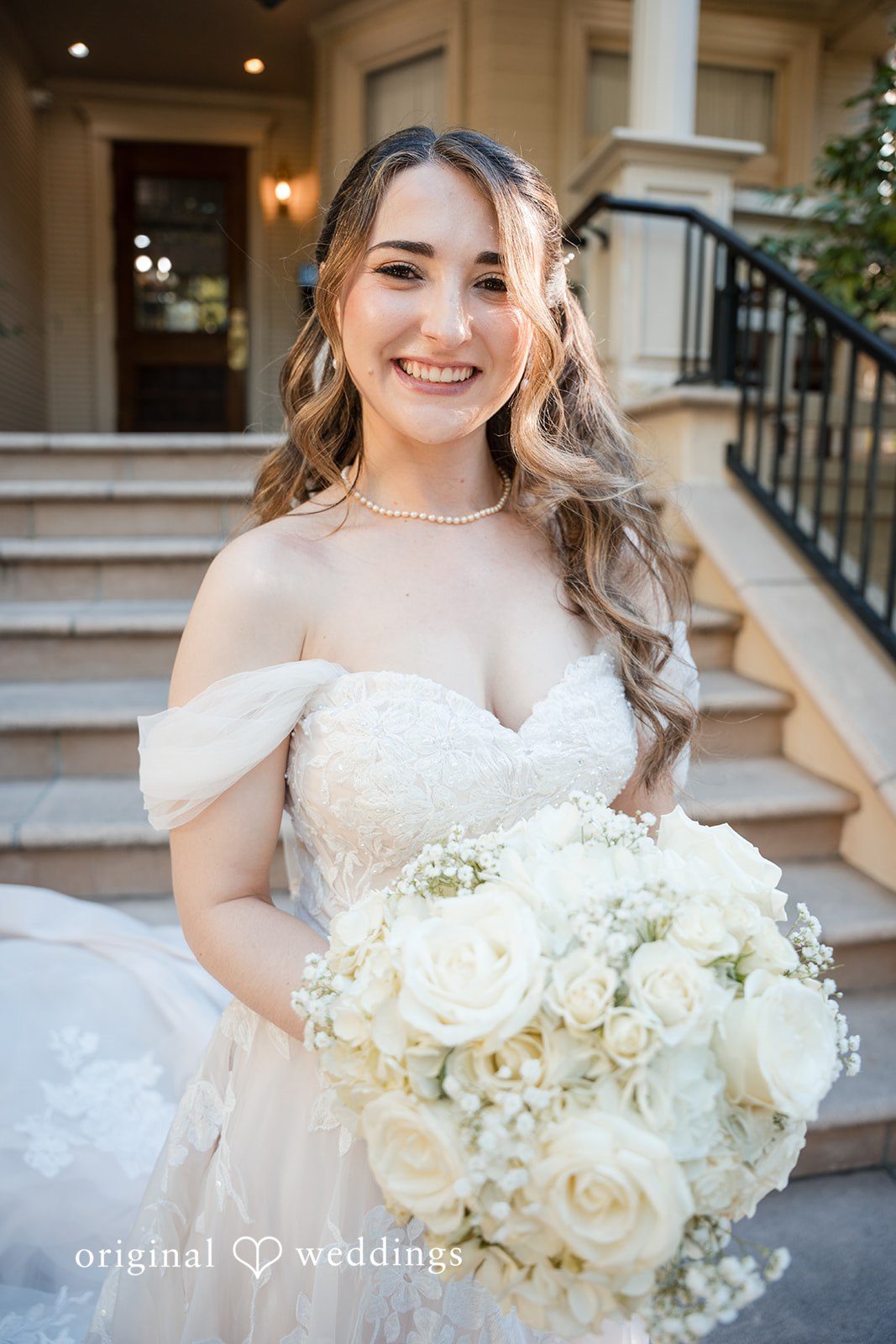 Close-up bridal portrait featuring a radiant smile and elegant white rose bouquet