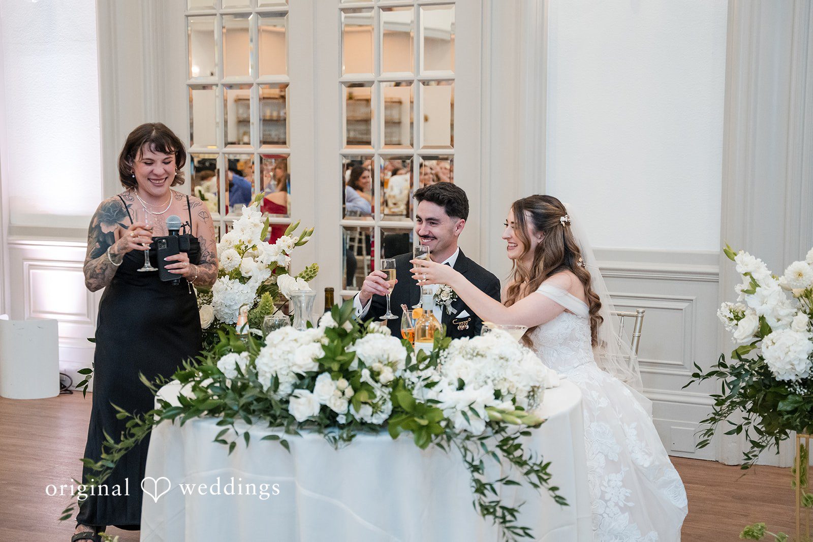 Bride and groom raising champagne glasses during their wedding reception at Sterling Hotel