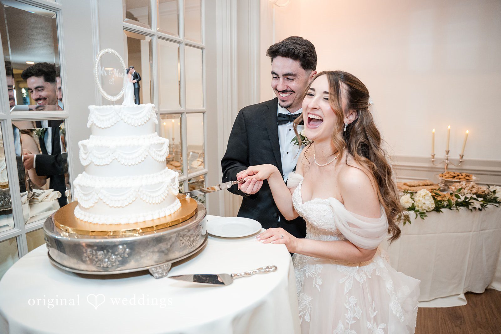 Joyful wedding cake cutting ceremony inside Sterling Hotel reception venue