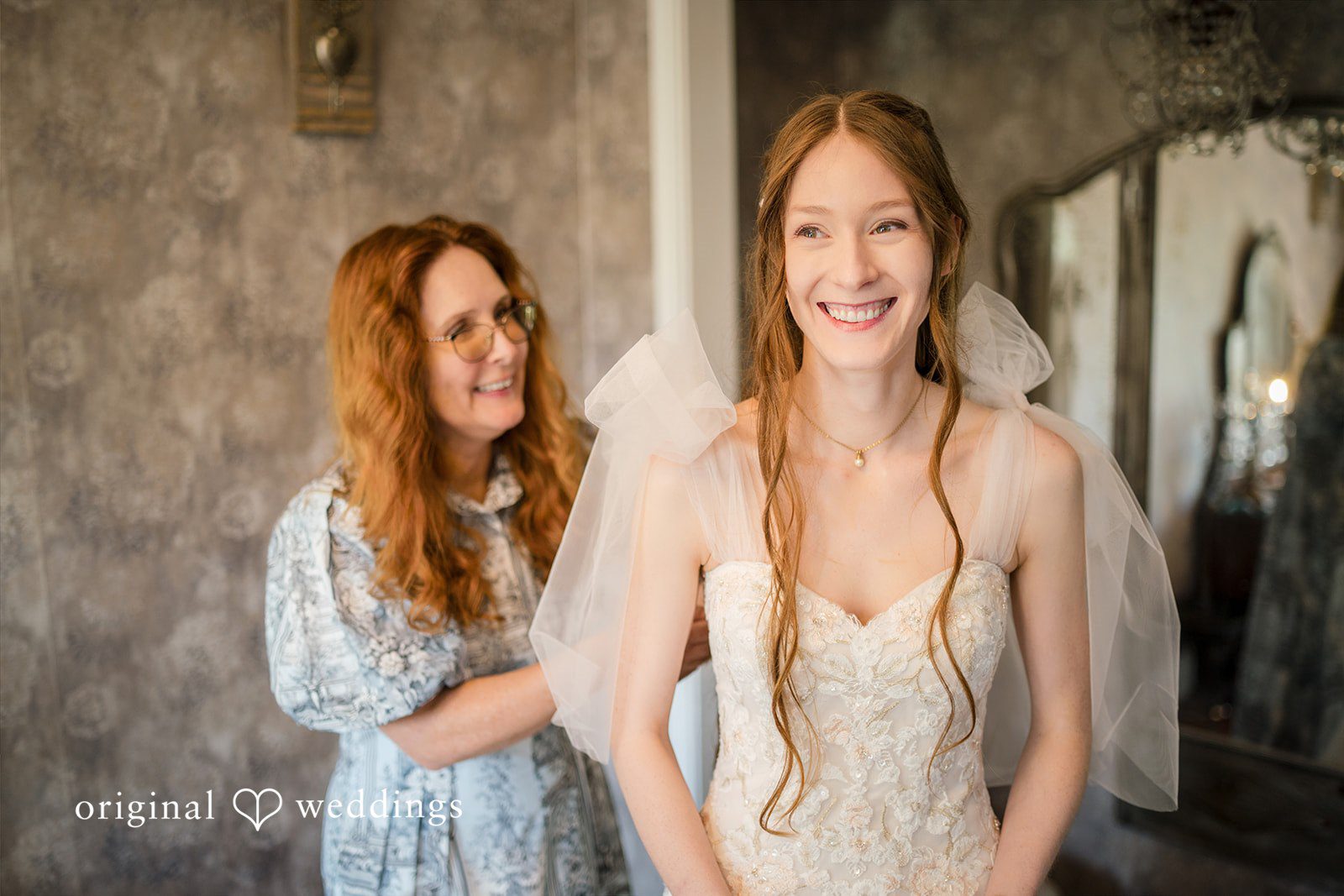 Morgan + Luke A bride smiles warmly alongside a woman assisting with her wedding veil.