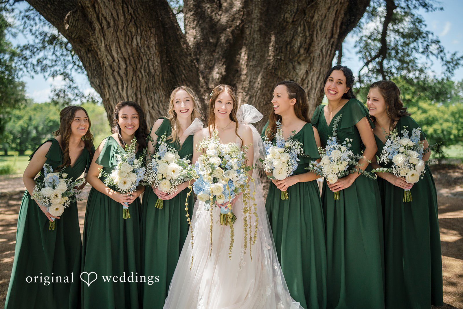 Morgan + Luke A bride stands centered among bridesmaids wearing matching forest green dresses.