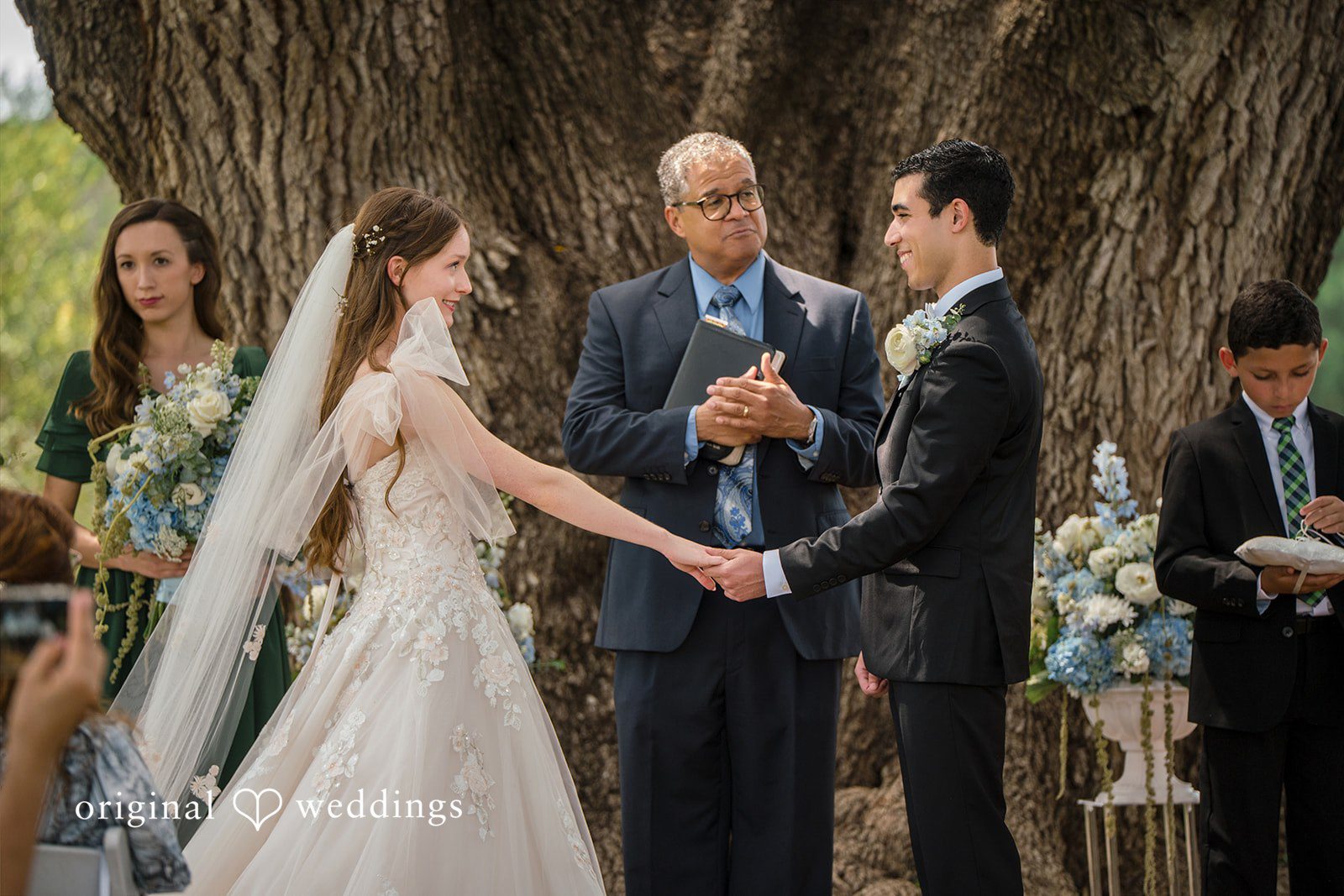 Morgan + Luke A bride and groom hold hands during their wedding ceremony.