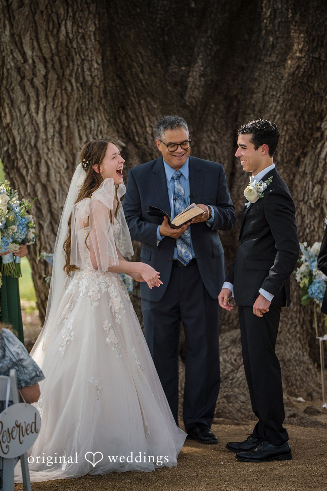Morgan + Luke A bride and groom stand with an officiant during their vows.