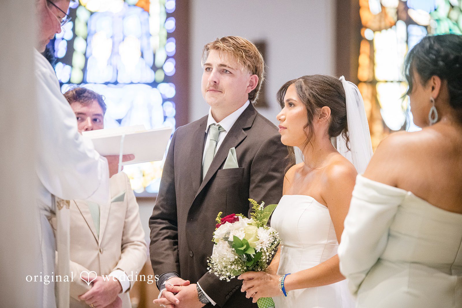 Couple posing together while looking at the priest at  San Pedro Catholic Church