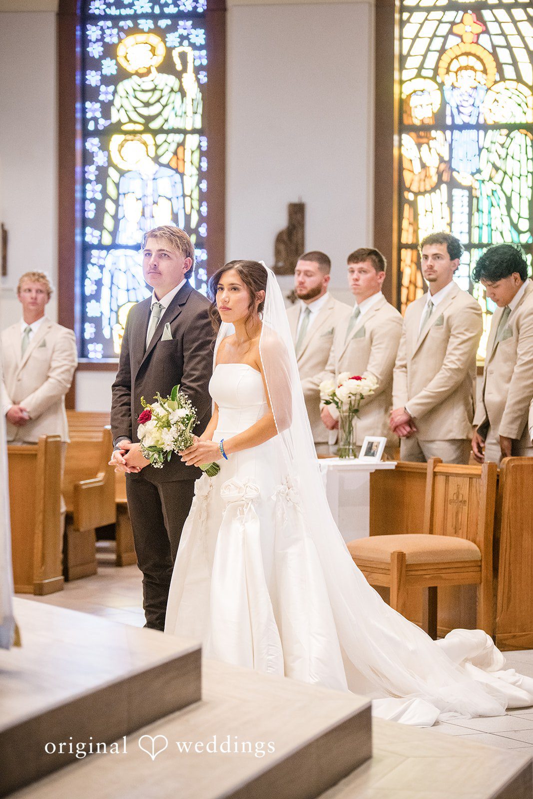 Bride and groom standing before the priest during the ceremony at  San Pedro Catholic Church