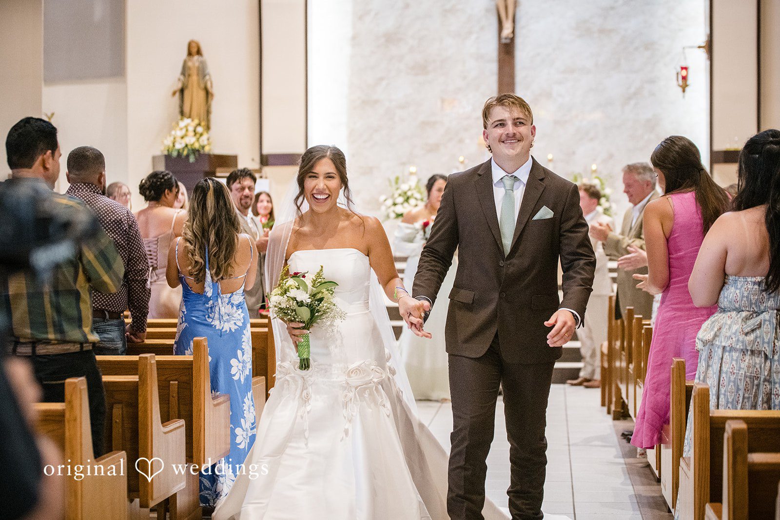 Tampa Wedding Photographers capturing couple walking outside after the ceremony at San Pedro Catholic Church by Original Weddings