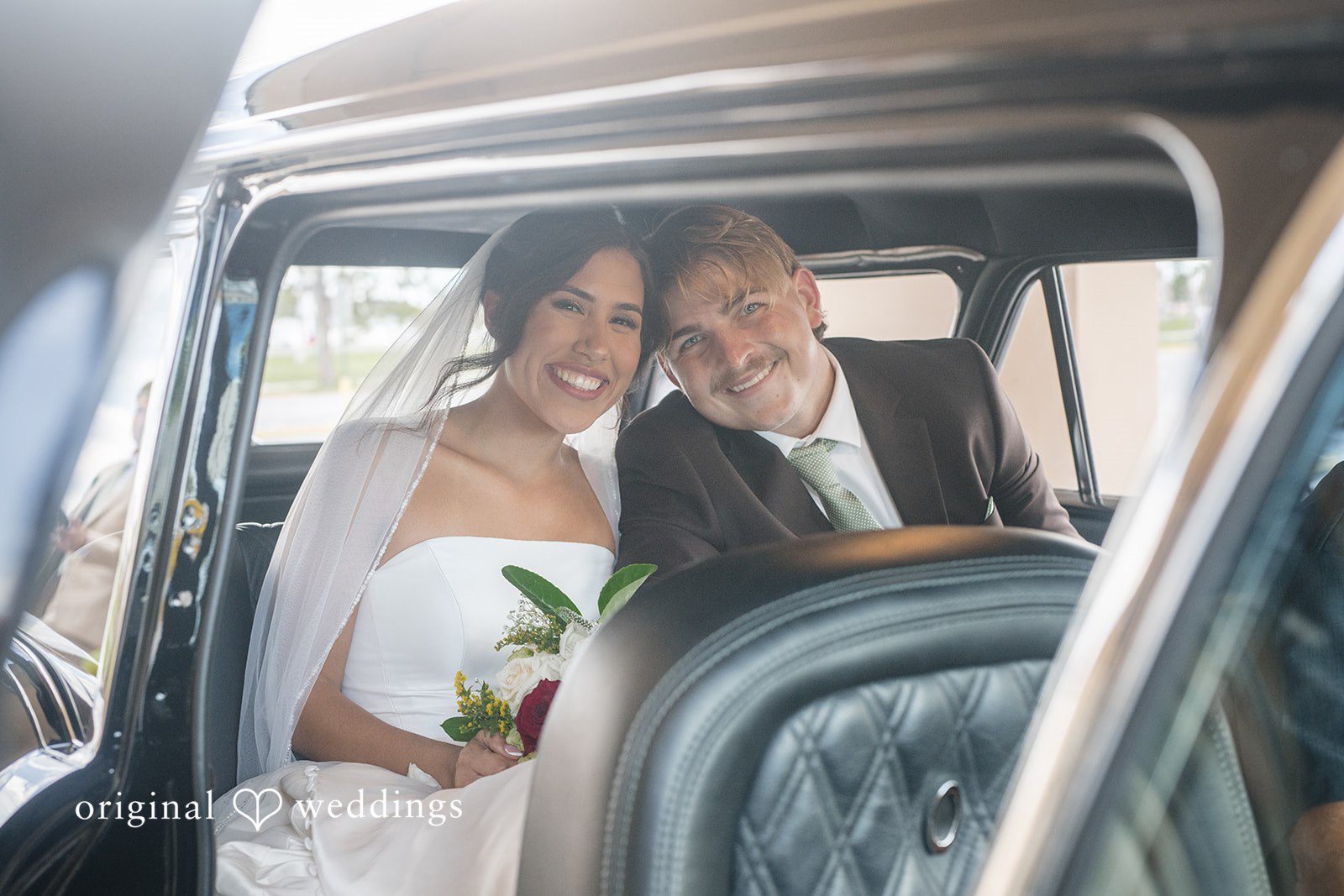 Bride and groom posing inside the wedding car at San Pedro Catholic Church
