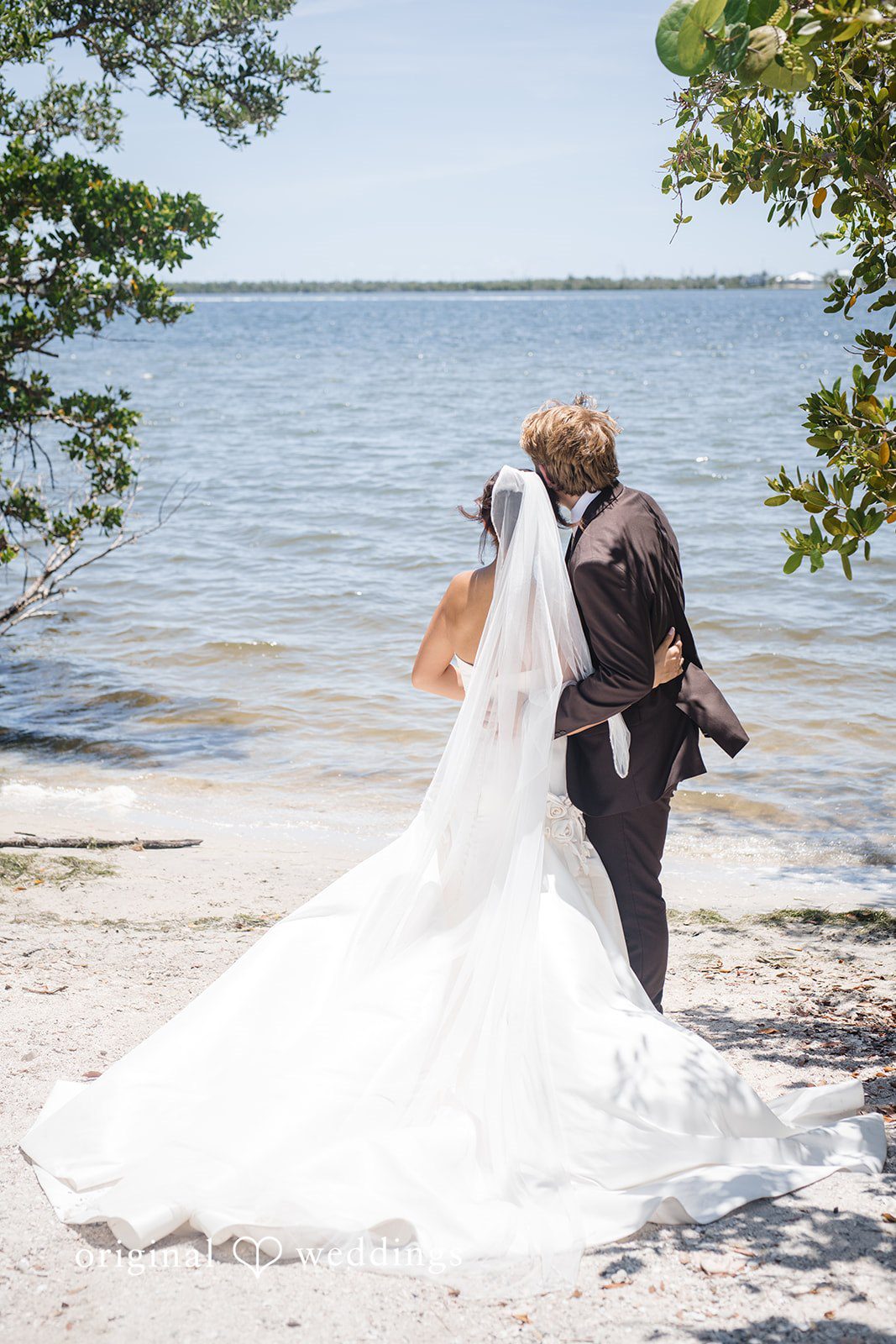 Back view of the bride and groom by the waterfront at San Pedro Catholic Church