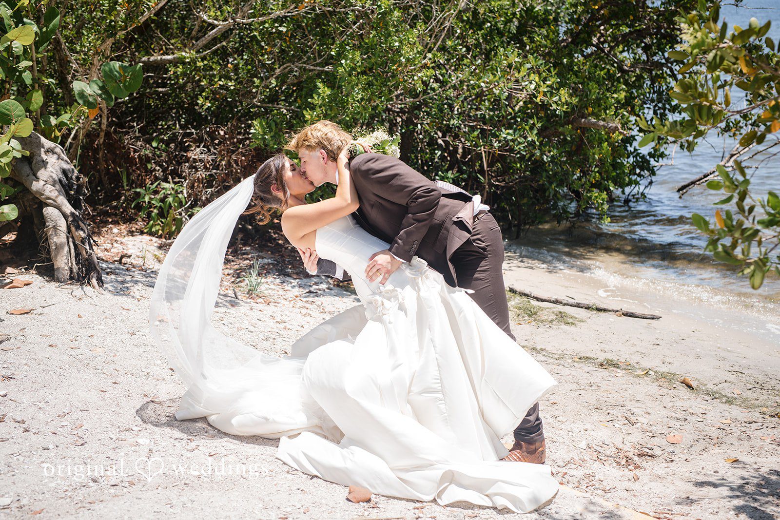 Bride and groom sharing a romantic lift and kiss at San Pedro Catholic Church