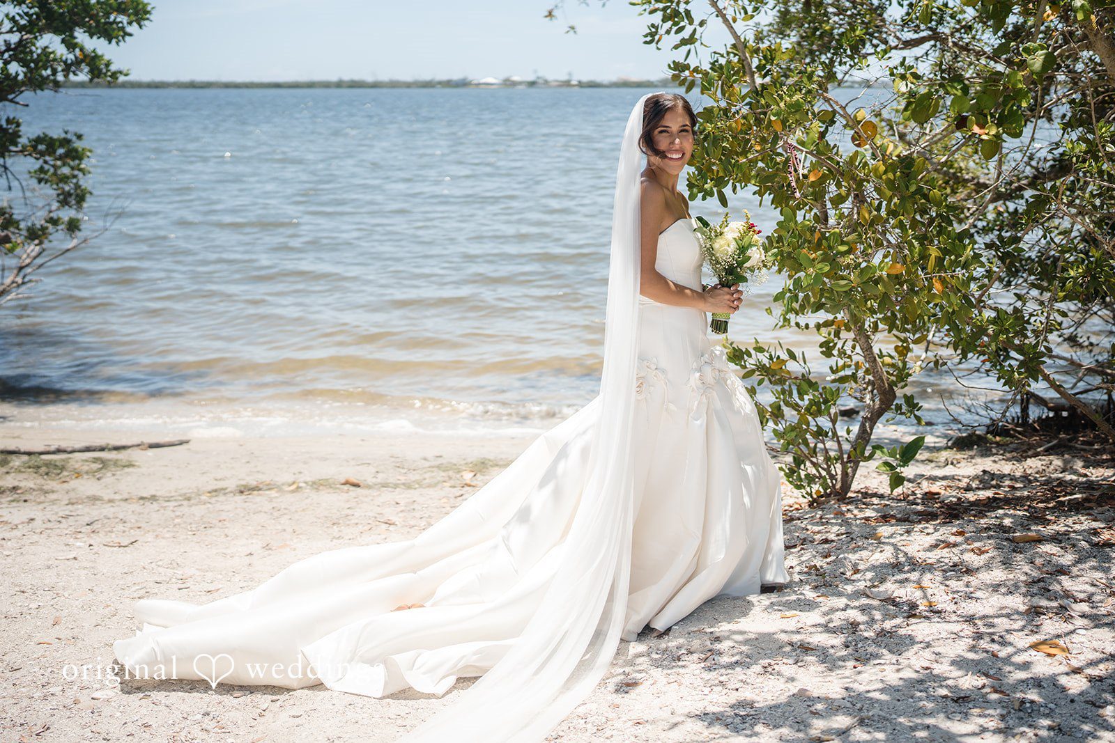 Elegant bride smiling with flowers at San Pedro Catholic Church