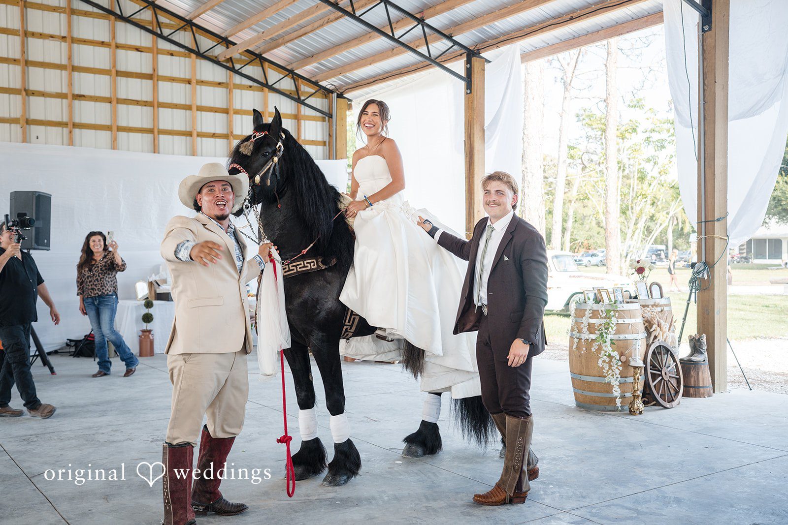 Bride sitting on the horse while the groom stands beside her at San Pedro Catholic Church