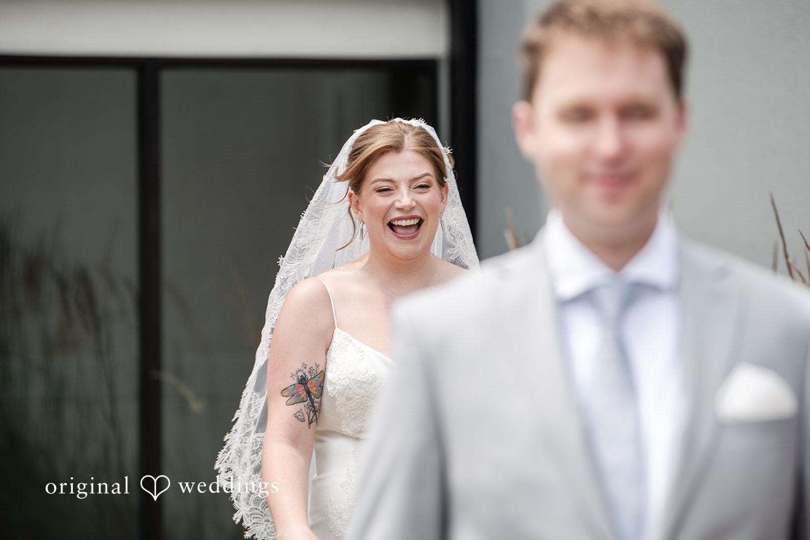 Groom standing in front as the bride walks from behind at Terrain Garden
