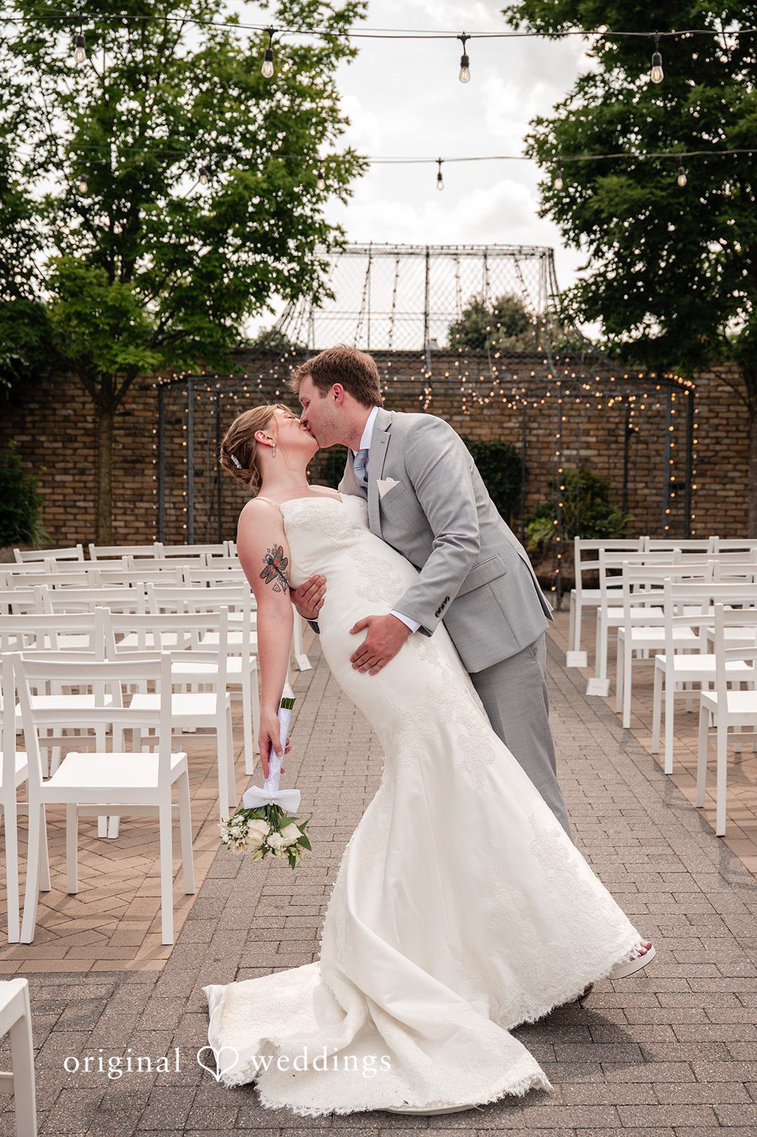 Groom lifting the bride while kissing her at Terrain Garden