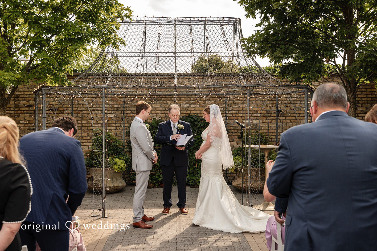 Couple standing before the priest at Terrain Garden