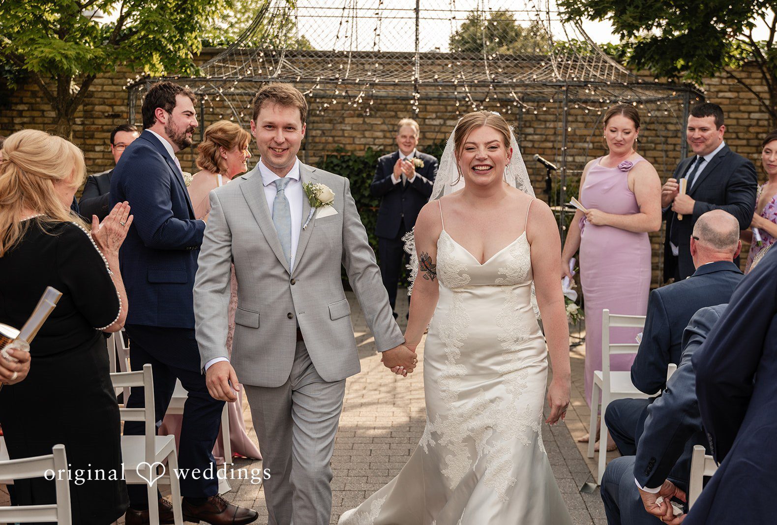 Philadelphia Wedding Photographers capturing groom and bride while leaving the altar smiling at Terrain Garden by Original Weddings