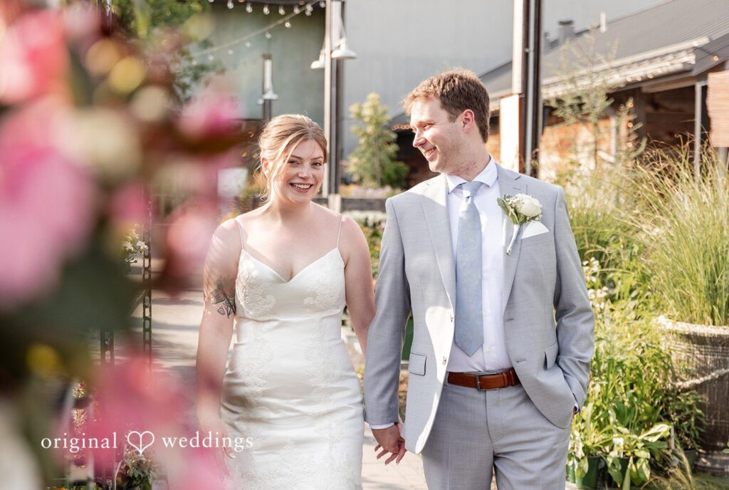 Philadelphia Wedding Photographers capturing groom looking at the bride while the bride looks ahead smiling at Terrain Garden by Original Weddings
