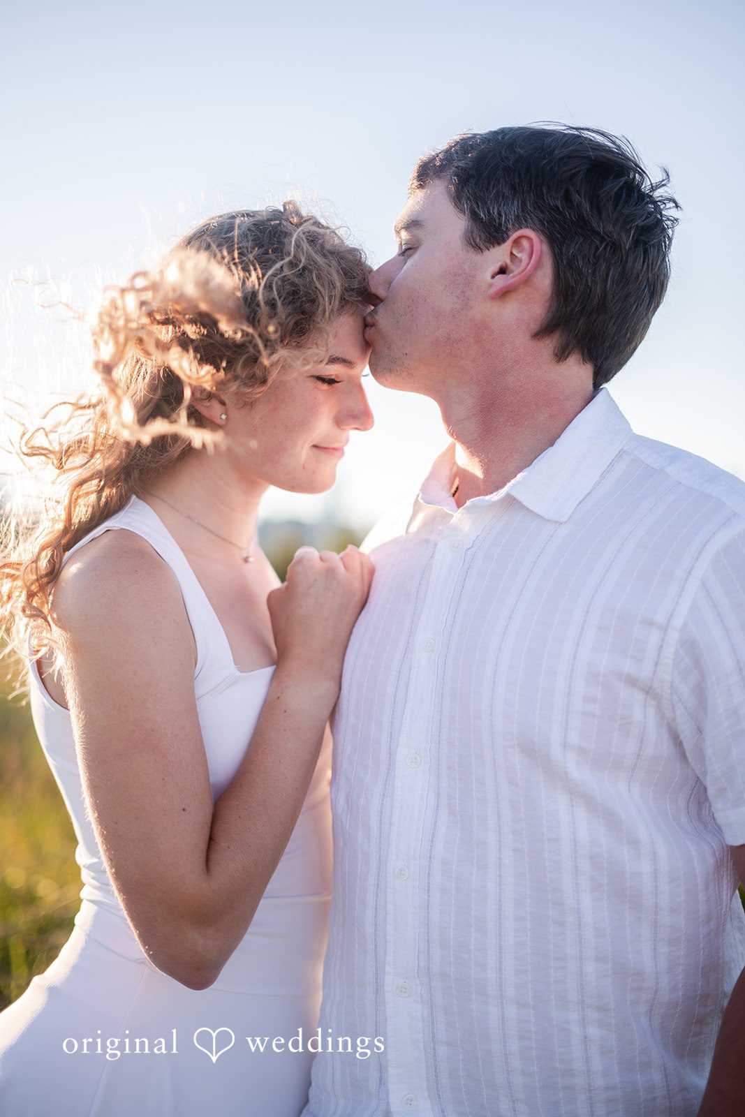 A man gently kissing a woman's forehead during a tender moment.