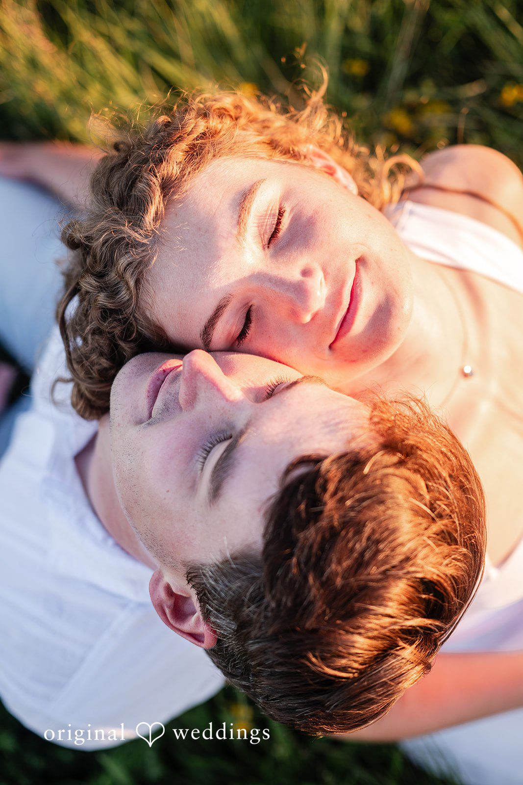 Close-up of a man and a woman lying down closely together on the ground.
