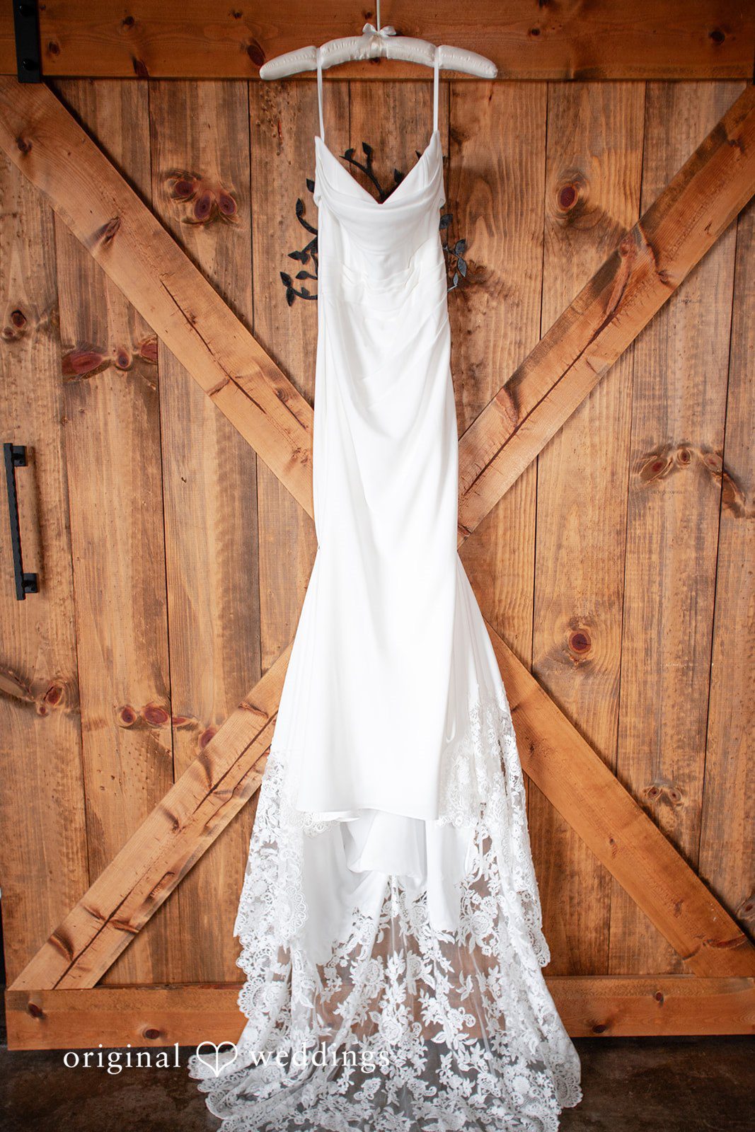 Madison + Ally Elegant lace wedding dress displayed on rustic wooden barn doors at The Barn at Matson Hill