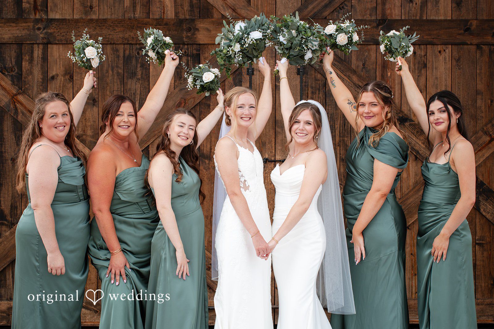 Madison + Ally Bridesmaids raise their bouquets while celebrating wedding at The Barn at Matson Hill.