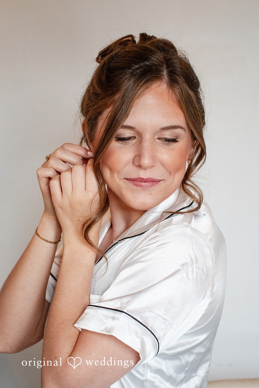 Madison + Ally Bride smiling while putting on her earrings before her wedding ceremony at The Barn at Matson Hill