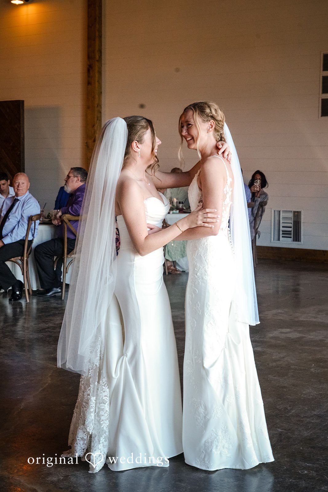Madison + Ally Romantic first dance between brides surrounded by family and friends at a rustic barn reception.