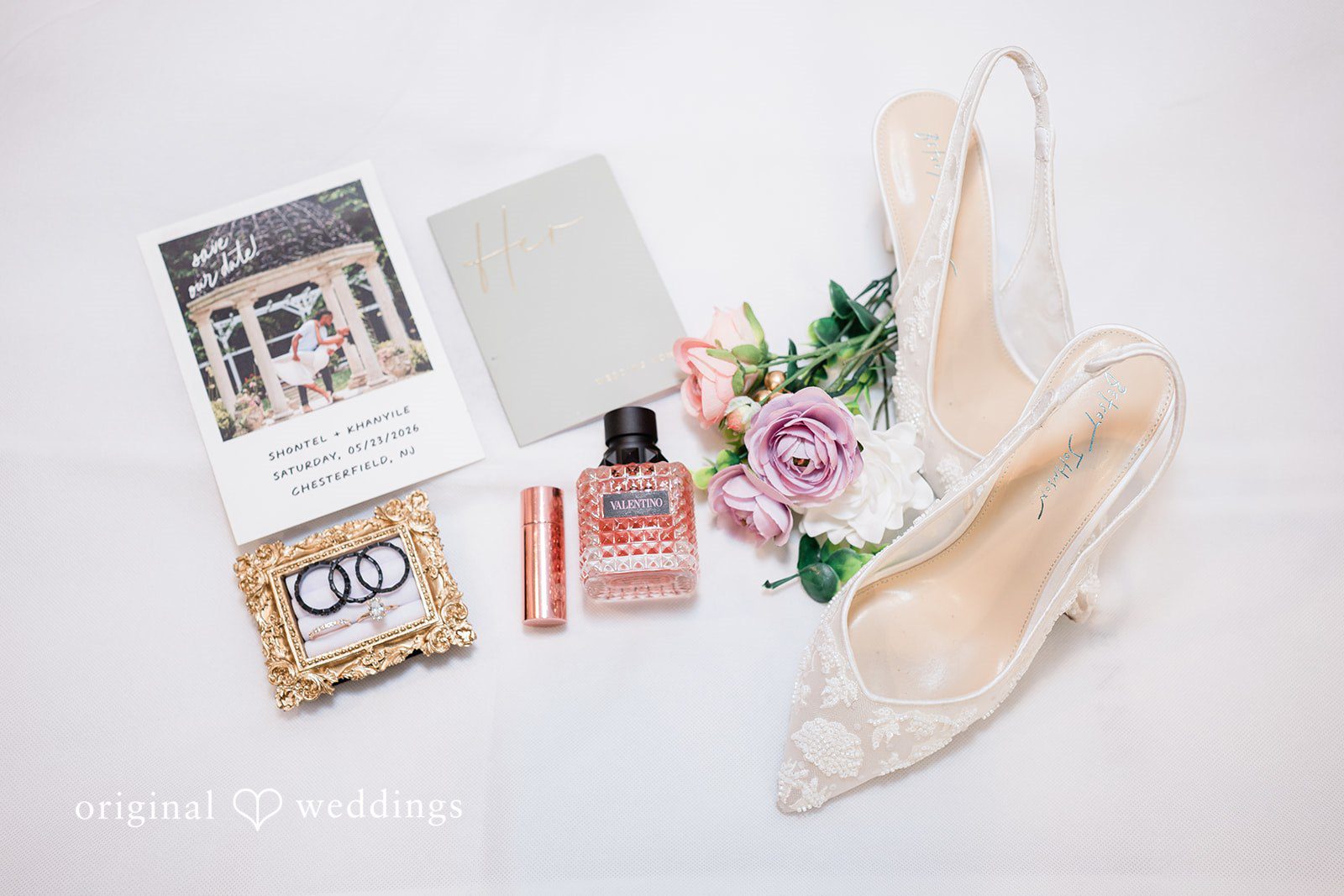 Khanyile + Shontel Wedding invitations, rings, and bridal accessories arranged together