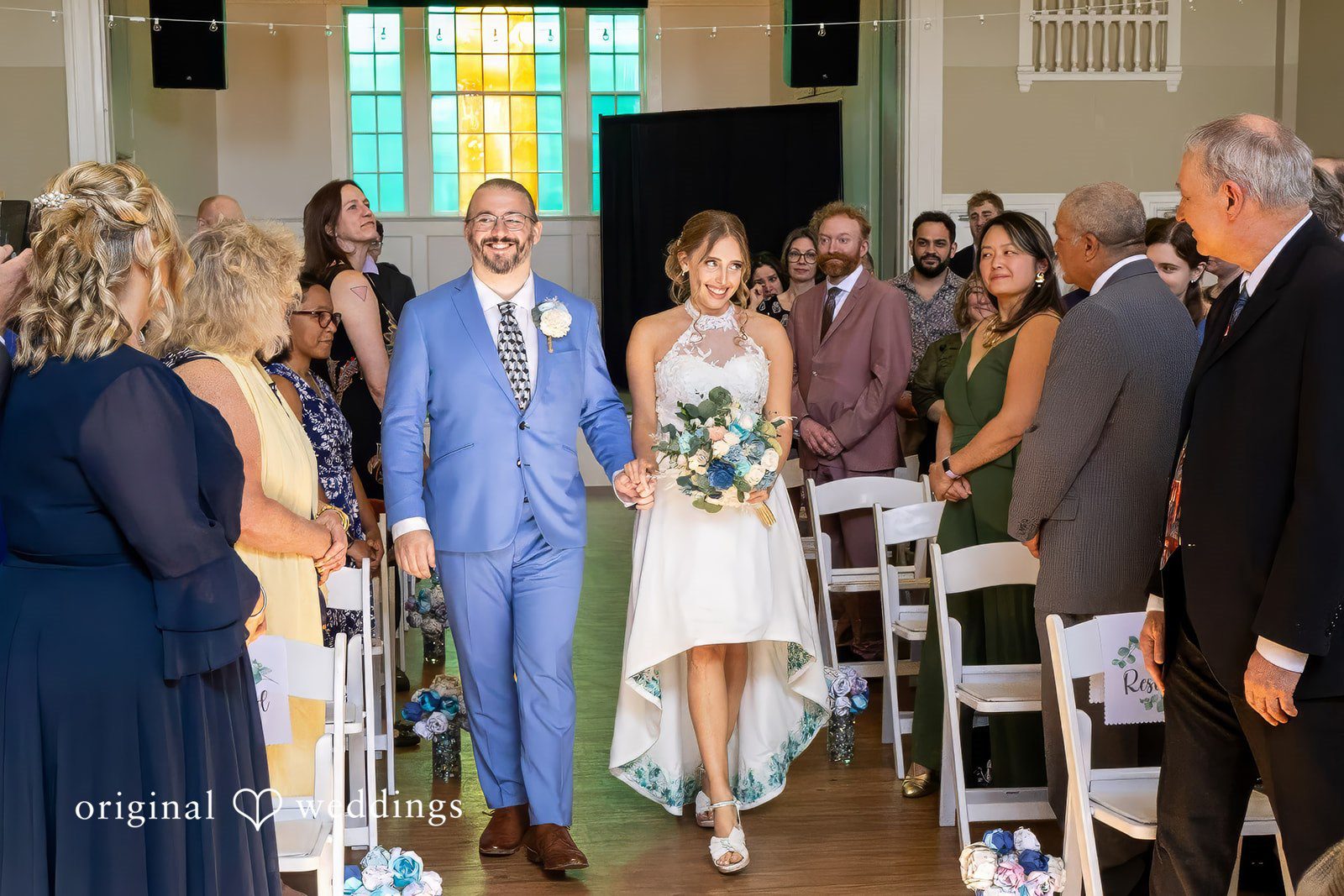 Sasha + Tom Bride and groom ceremony entrance while holding hands at The Great Hall at Green Lake