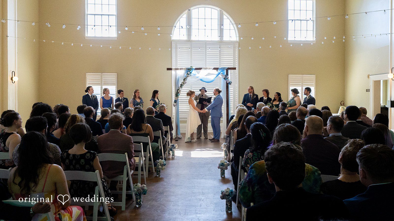 Sasha + Tom Bride and groom holding hands during ceremony at The Great Hall at Green Lake