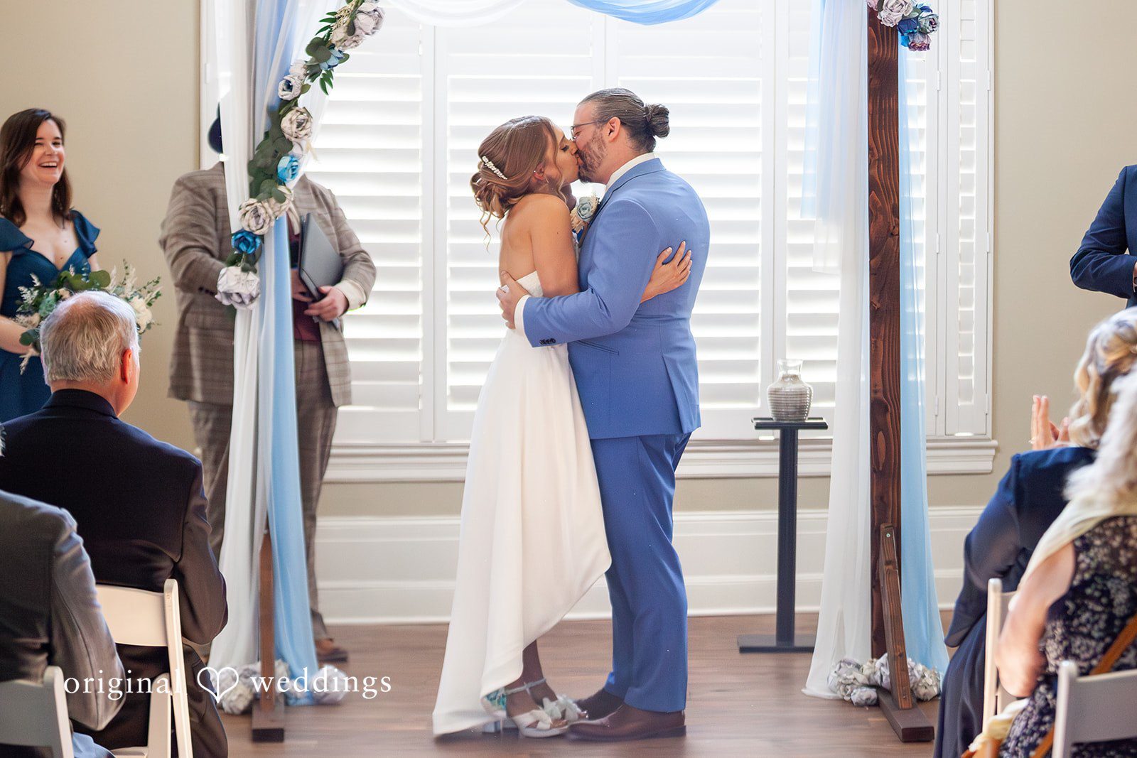Sasha + Tom Seattle Wedding Photographers capturing couple kissing during the ceremony at The Great Hall at Green Lake by Original Weddings