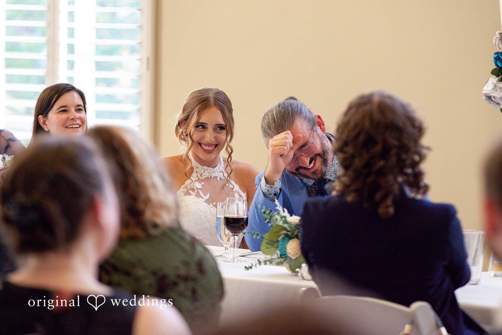 Sasha + Tom Bride and groom smiling at reception table at The Great Hall at Green Lake