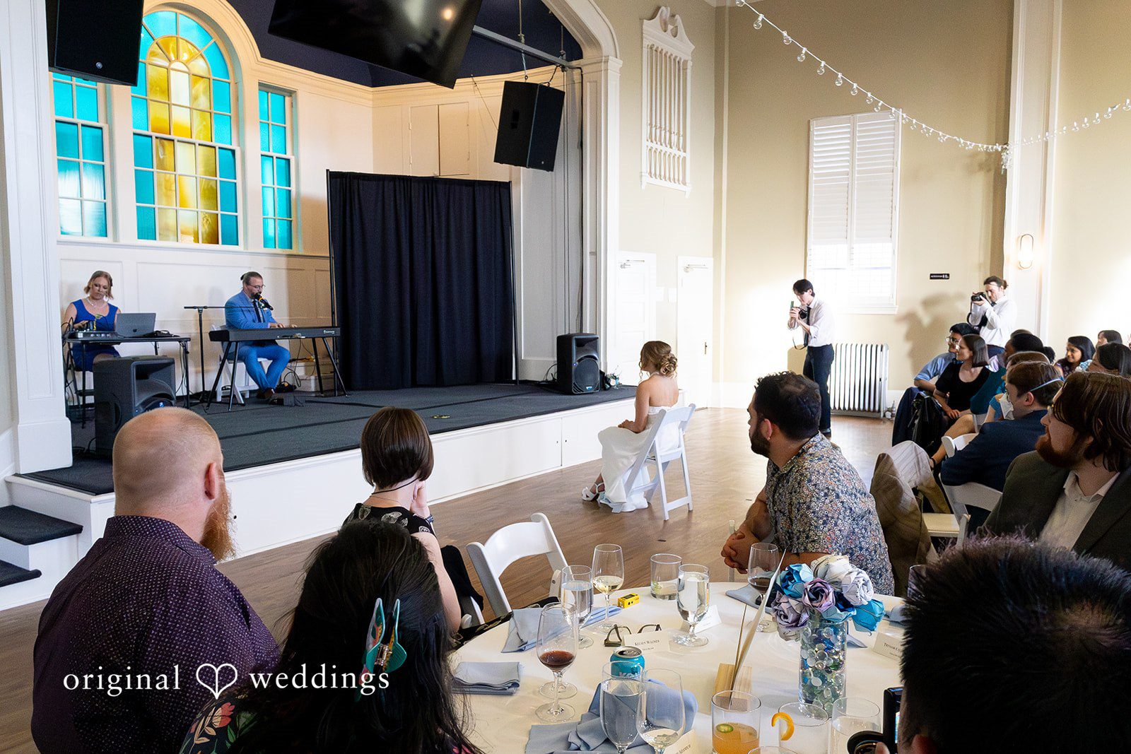Sasha + Tom Couple sharing a quiet reception moment while seated at the table at The Great Hall at Green Lake