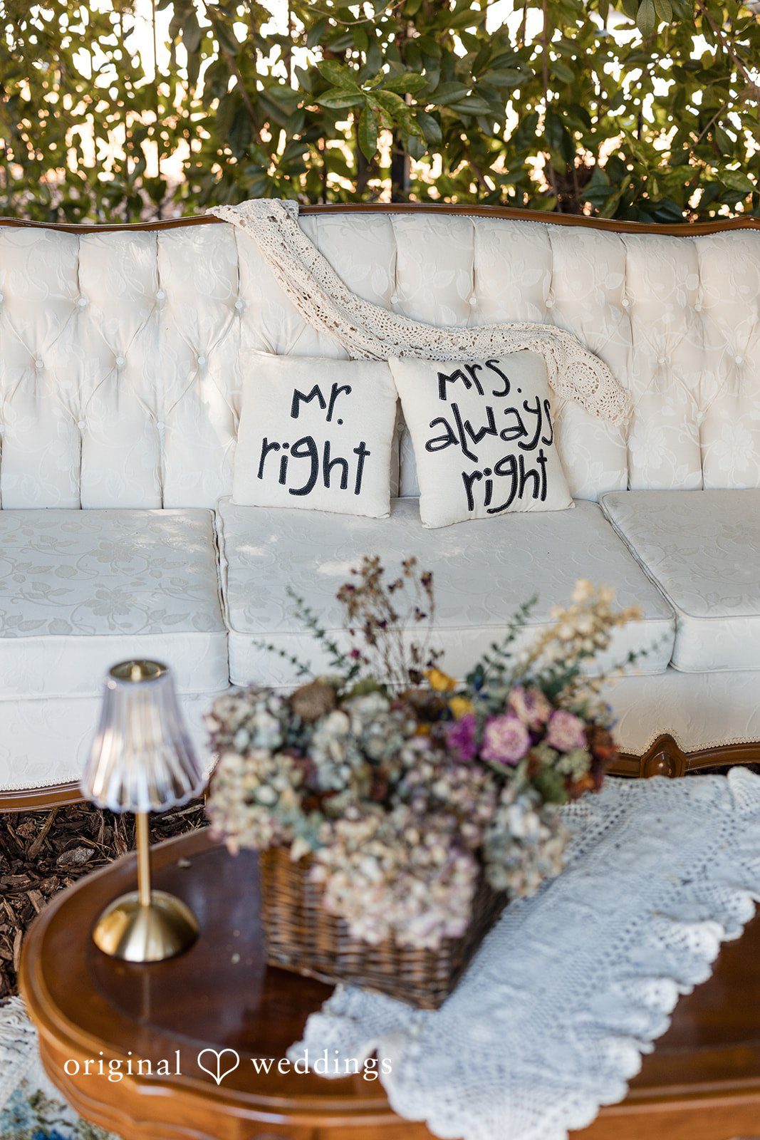 Avery + Ryan A lounge seating area featuring a white sofa decorated with personalized wedding pillows.