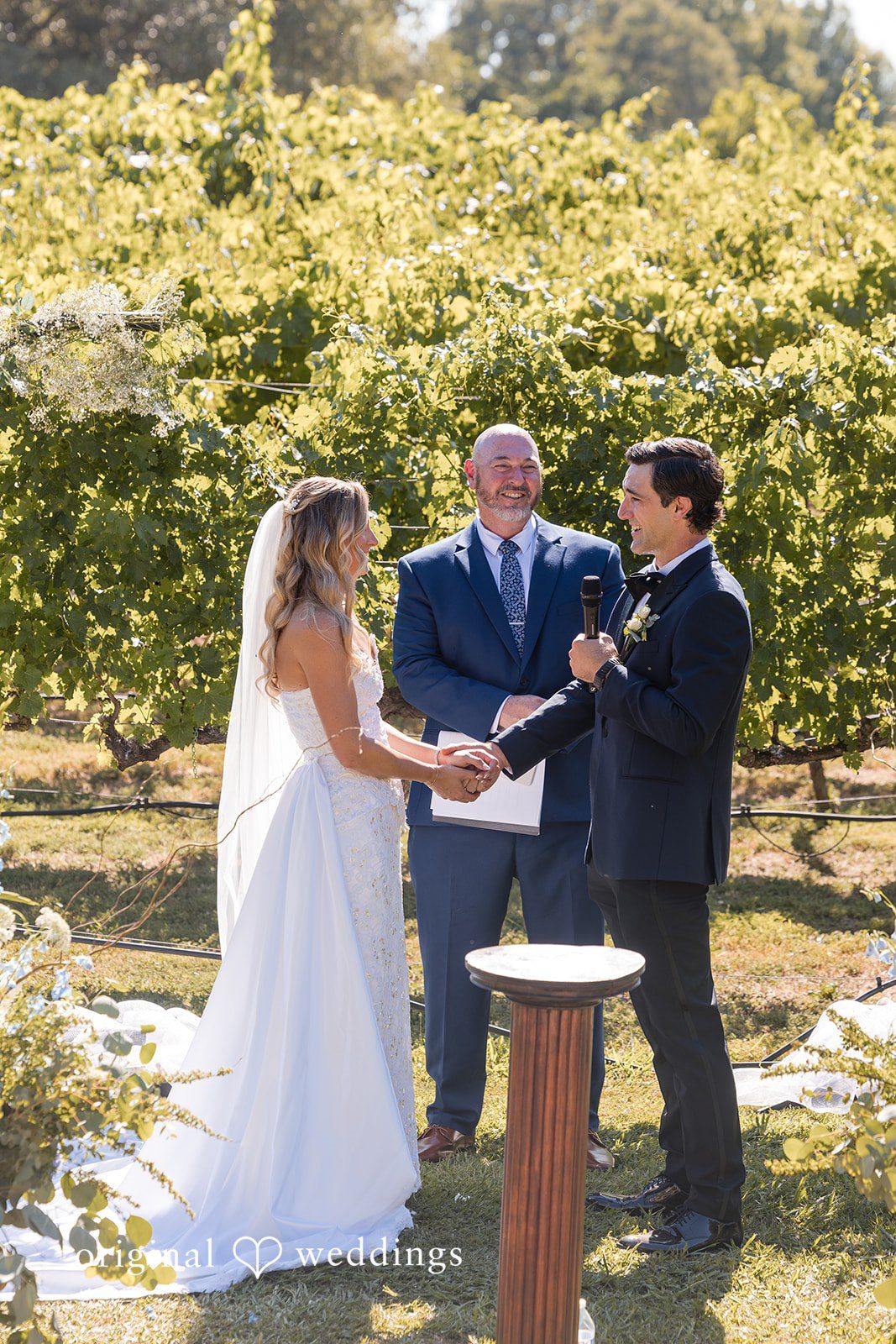 Avery + Ryan A bride and groom exchanging vows in front of an officiant.