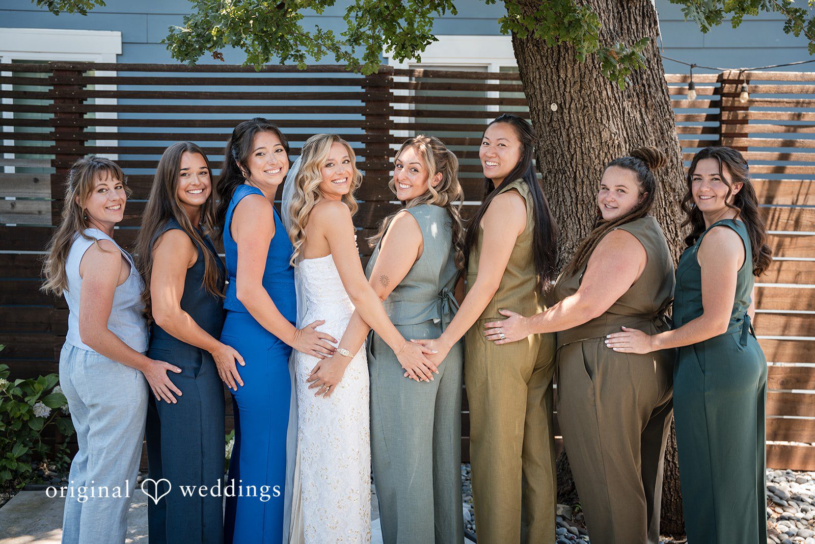 Avery + Ryan Bride and bridesmaids posing together while wearing various shades of blue and green dresses.