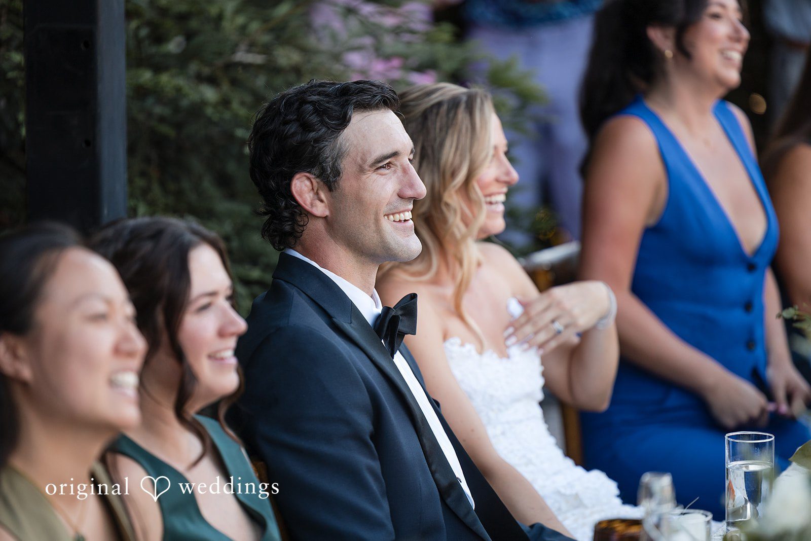 Avery + Ryan A side profile view of a bride and groom watching a speech at their reception.