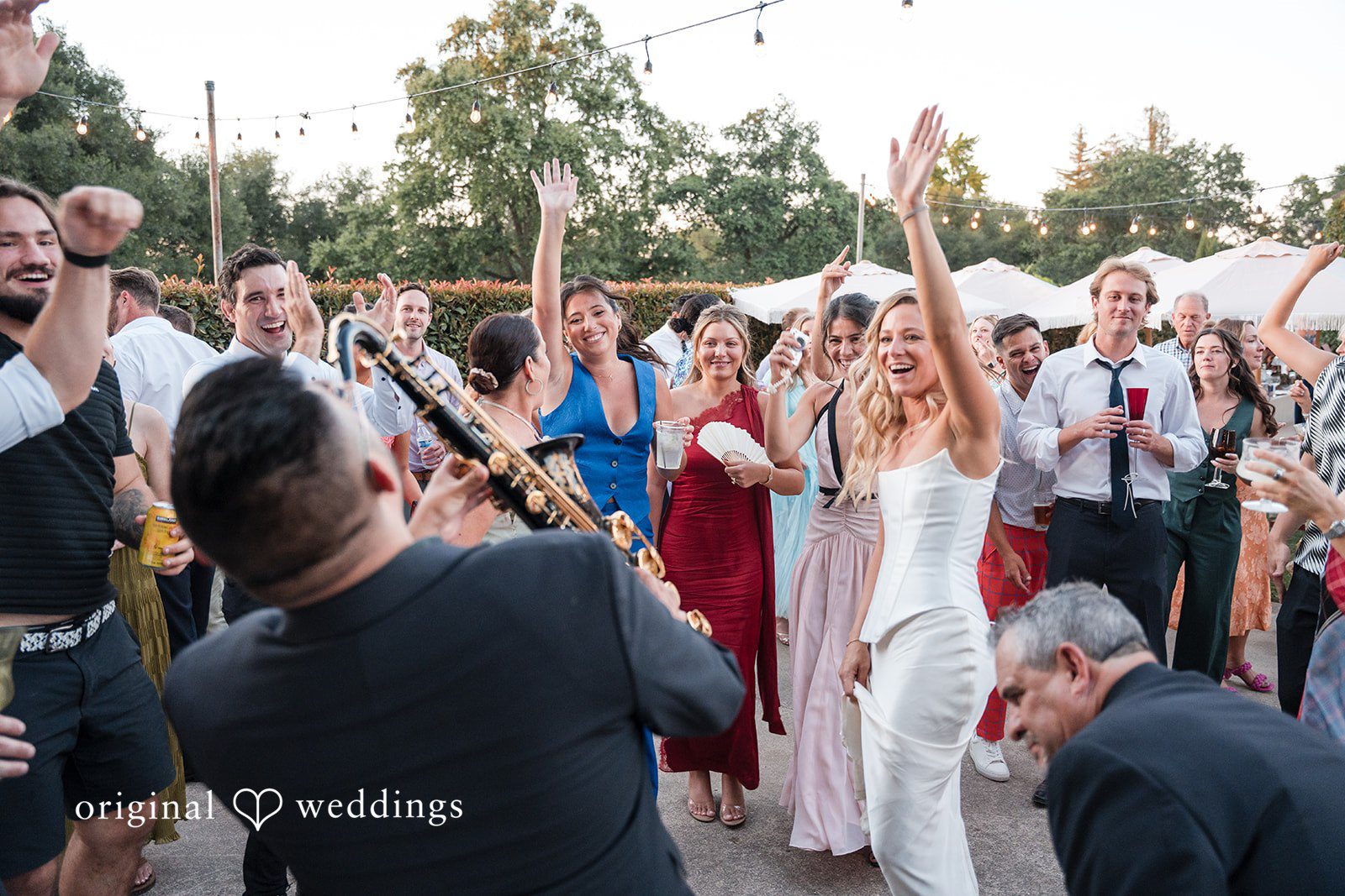 Avery + Ryan A saxophone player performing live in front of a dancing crowd of wedding guests.