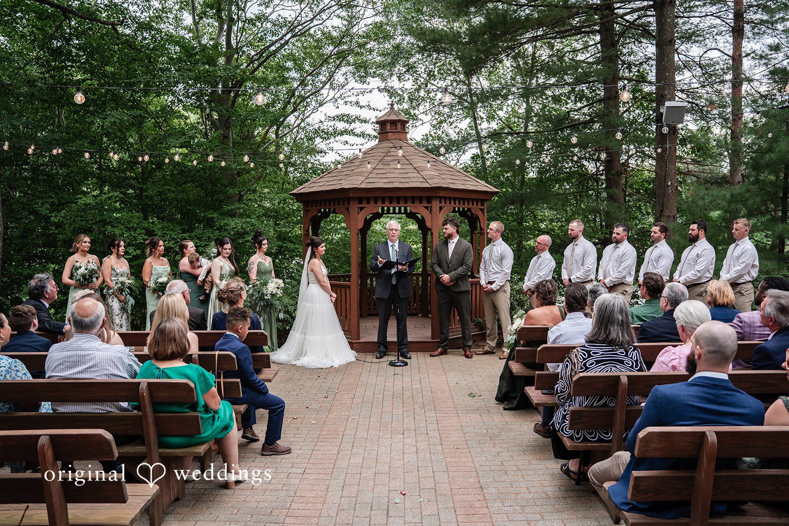Couple sharing a meaningful ceremony moment before exchanging their vows at The Pavilion on Crystal Lake captured by Hartford CT Wedding Photographers from Original Weddings.