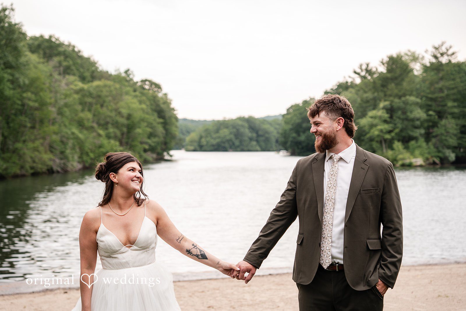 Bride and groom holding hands while posing at The Pavilion on Crystal Lake captured by Hartford CT Wedding Photographers from Original Weddings.