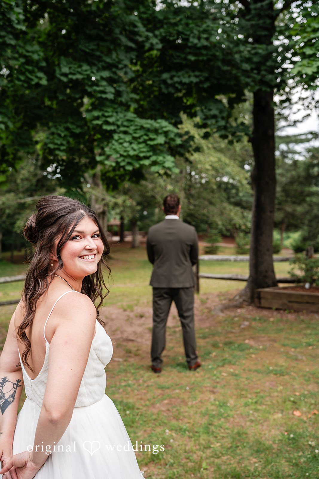 Happy bride smiling as she approaches the groom for their first look.