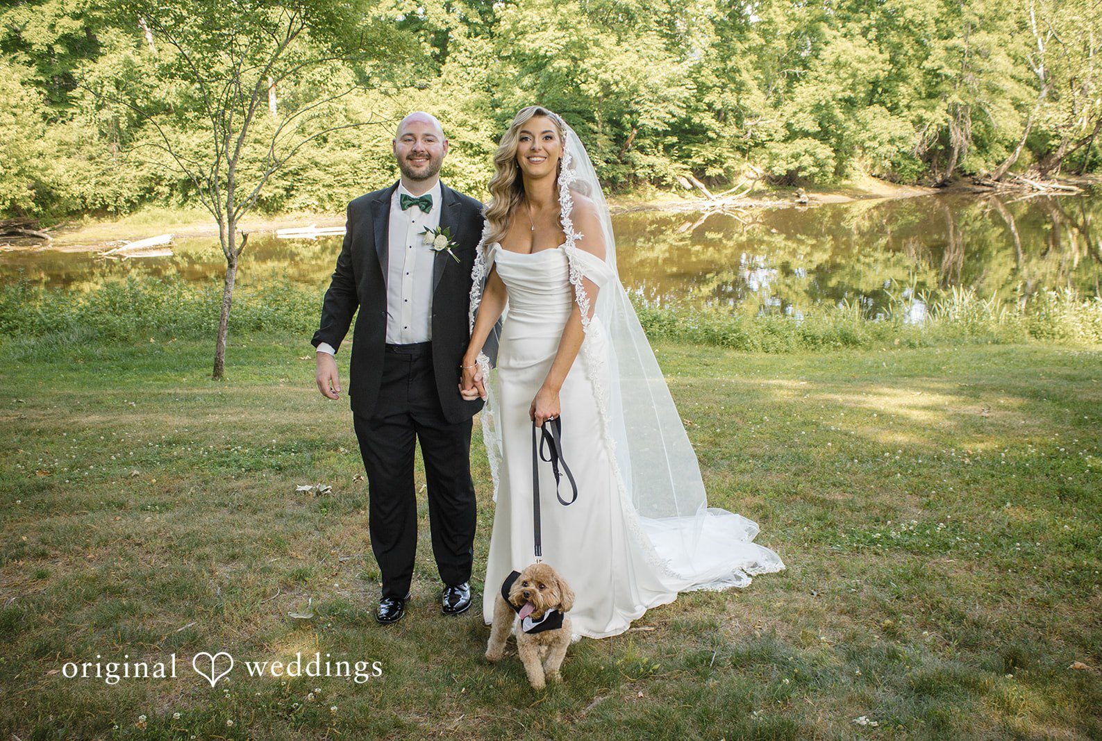 Bride and groom walking together at The Riverview with beautiful pet captured by Hartford CT wedding photographers from Original Weddings